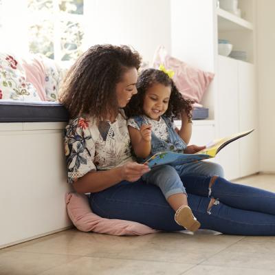 Woman and little girl read together